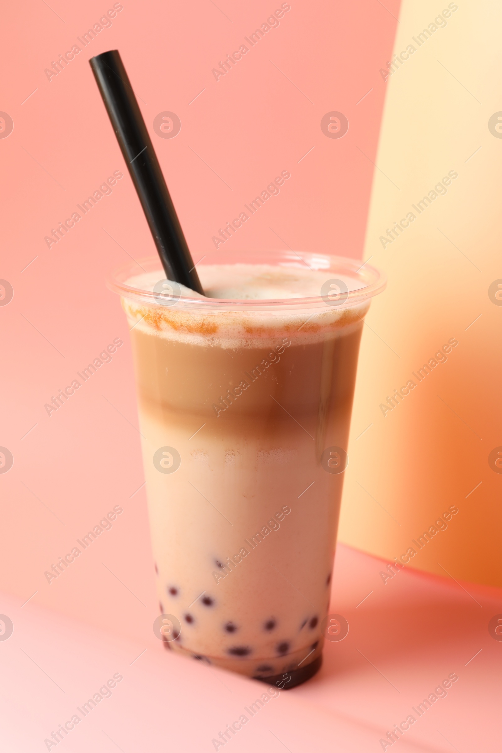 Tasty milk bubble tea in plastic cup on pink background, closeup Photo of Tasty milk bubble tea in plastic cup on pink background, closeup