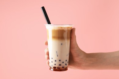 Photo of Woman with tasty milk bubble tea on pink background, closeup