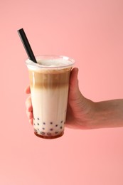 Photo of Woman with tasty milk bubble tea on pink background, closeup