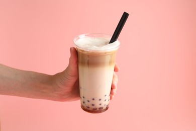 Photo of Woman with tasty milk bubble tea on pink background, closeup