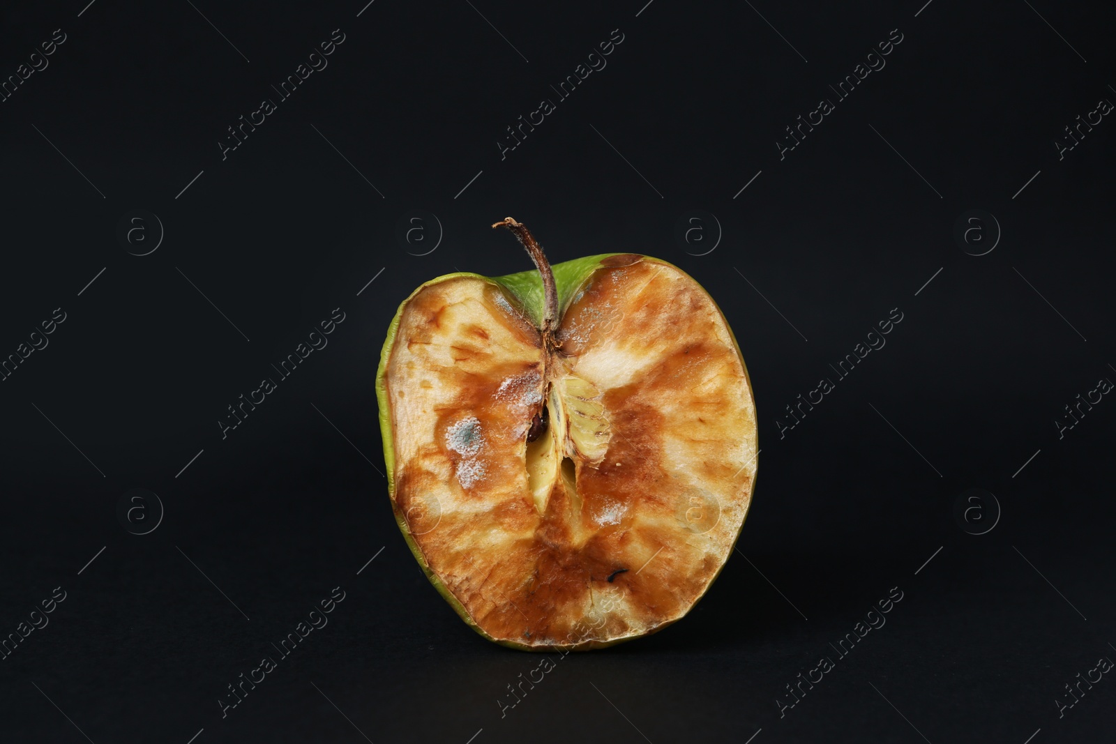 Half of spoiled apple on black background Photo of Half of spoiled apple on black background