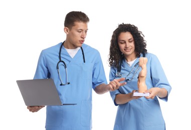 Photo of Medical students with laptop and human body model on white background