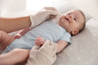 Photo of Pediatrician examining baby at table in clinic, closeup
