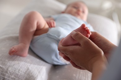 Photo of Pediatrician examining baby at table in clinic, closeup