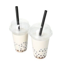 Photo of Tasty milk bubble tea in plastic cups isolated on white