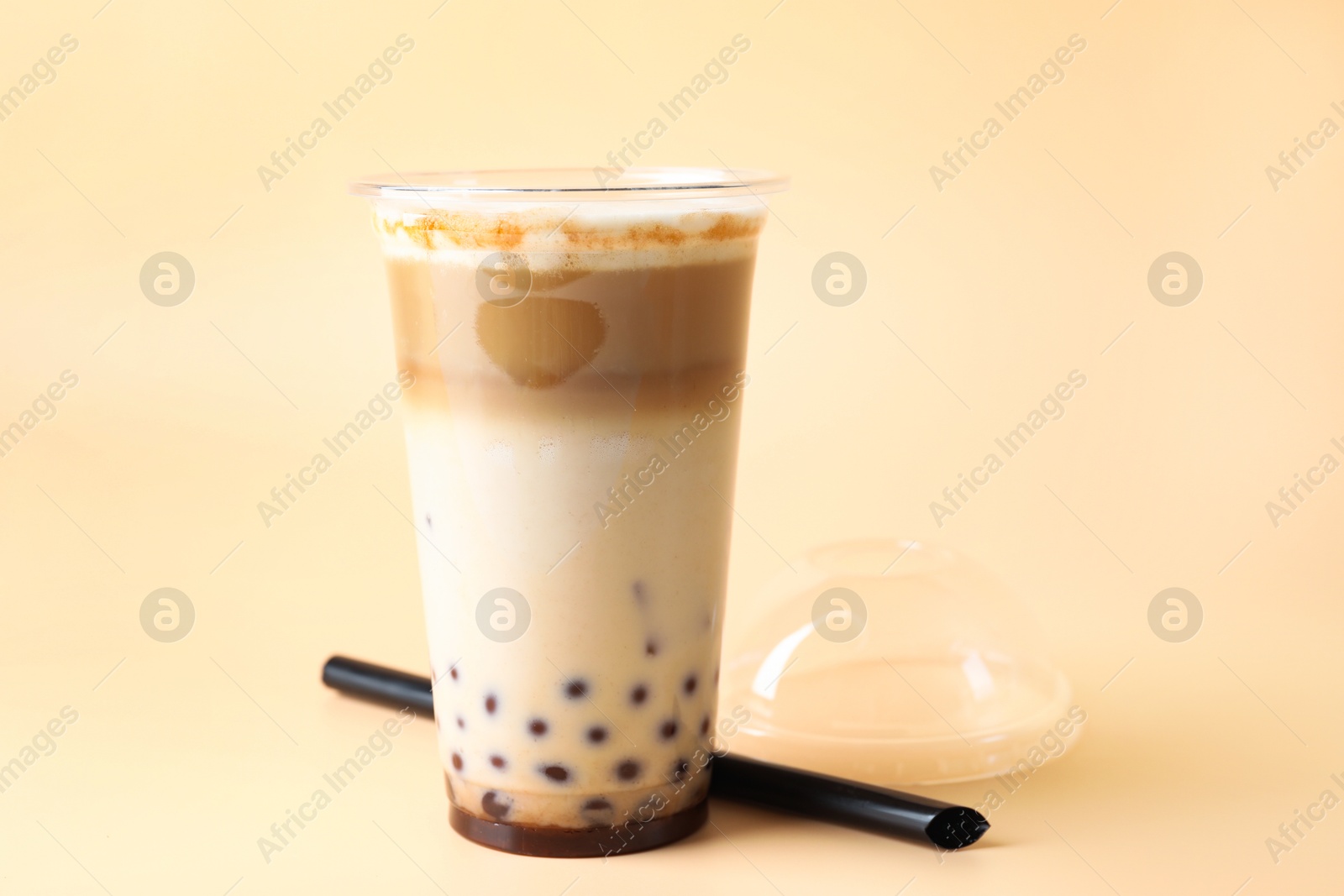 Tasty milk bubble tea in plastic cup on beige background, closeup. Space for text Photo of Tasty milk bubble tea in plastic cup on beige background, closeup. Space for text
