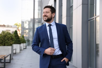 Photo of Portrait of successful businessman near office building