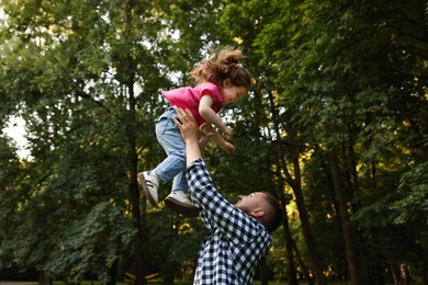 Photo of Happy Father's Day. Dad and his little daughter spending time together in park, low angle view