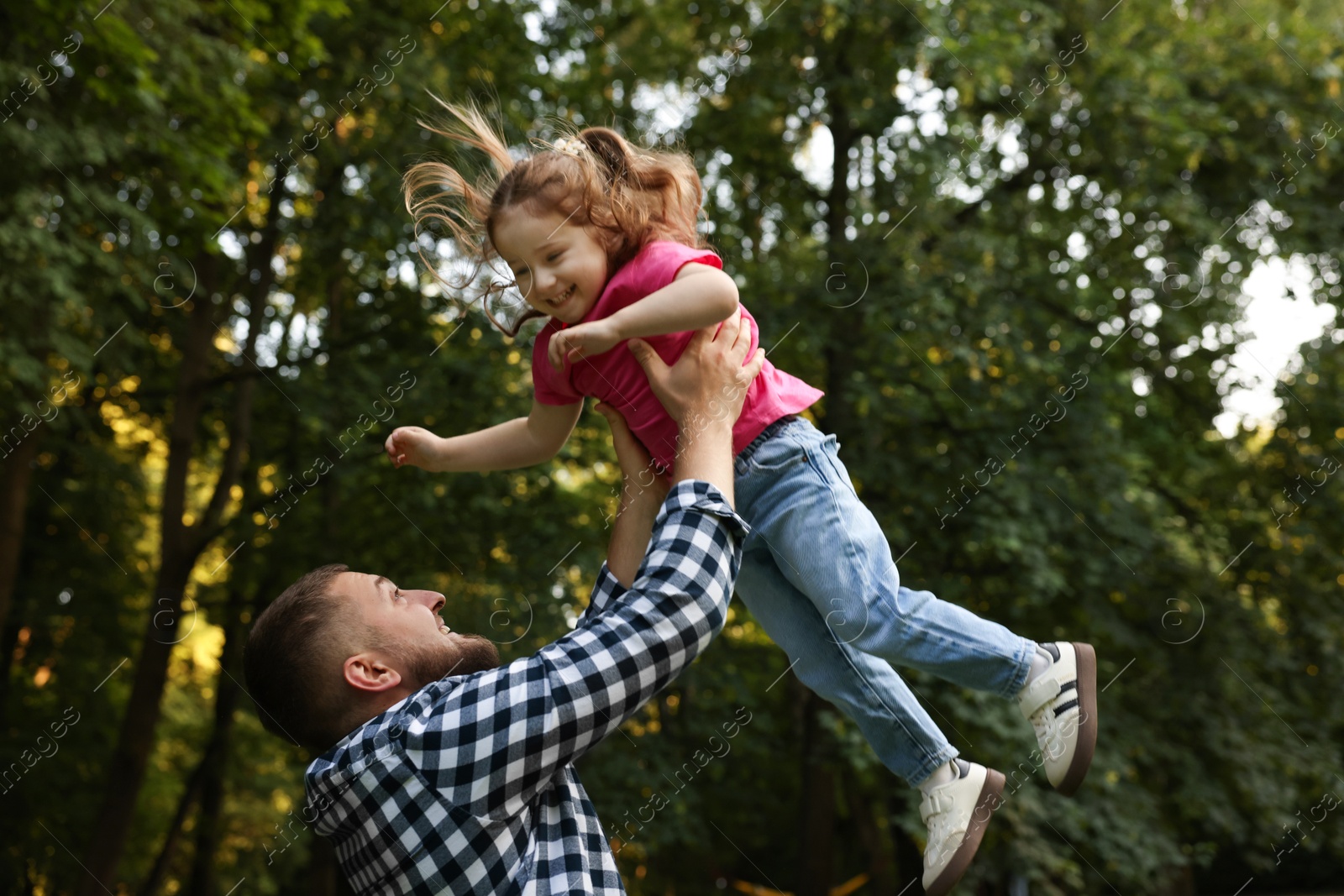 Happy Father's Day. Dad and his little daughter spending time together in park, low angle view Photo of Happy Father's Day. Dad and his little daughter spending time together in park, low angle view
