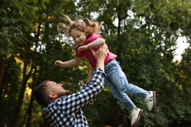 Photo of Happy Father's Day. Dad and his little daughter spending time together in park, low angle view