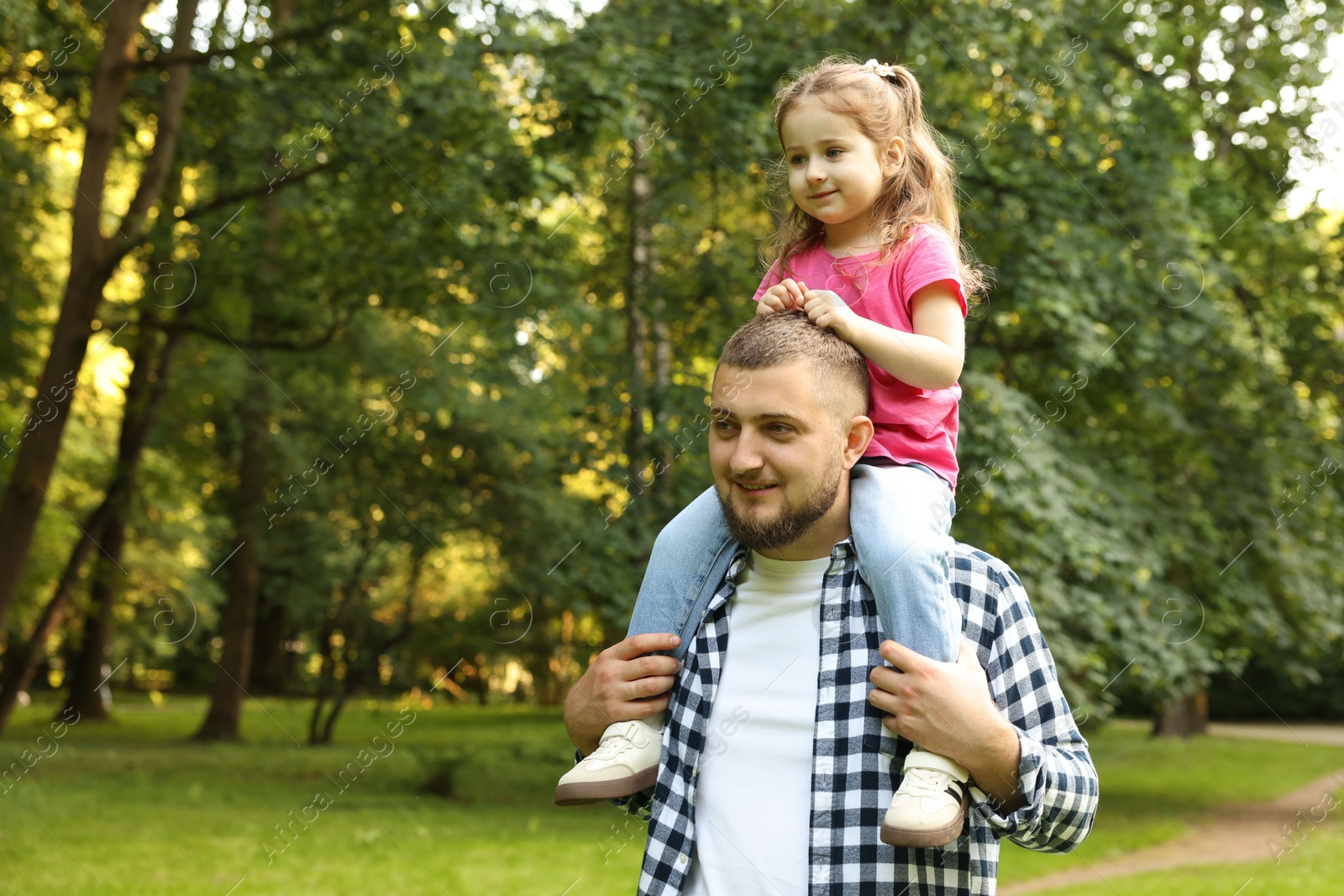 Happy Father's Day. Dad and his little daughter spending time together in park, space for text Photo of Happy Father's Day. Dad and his little daughter spending time together in park, space for text