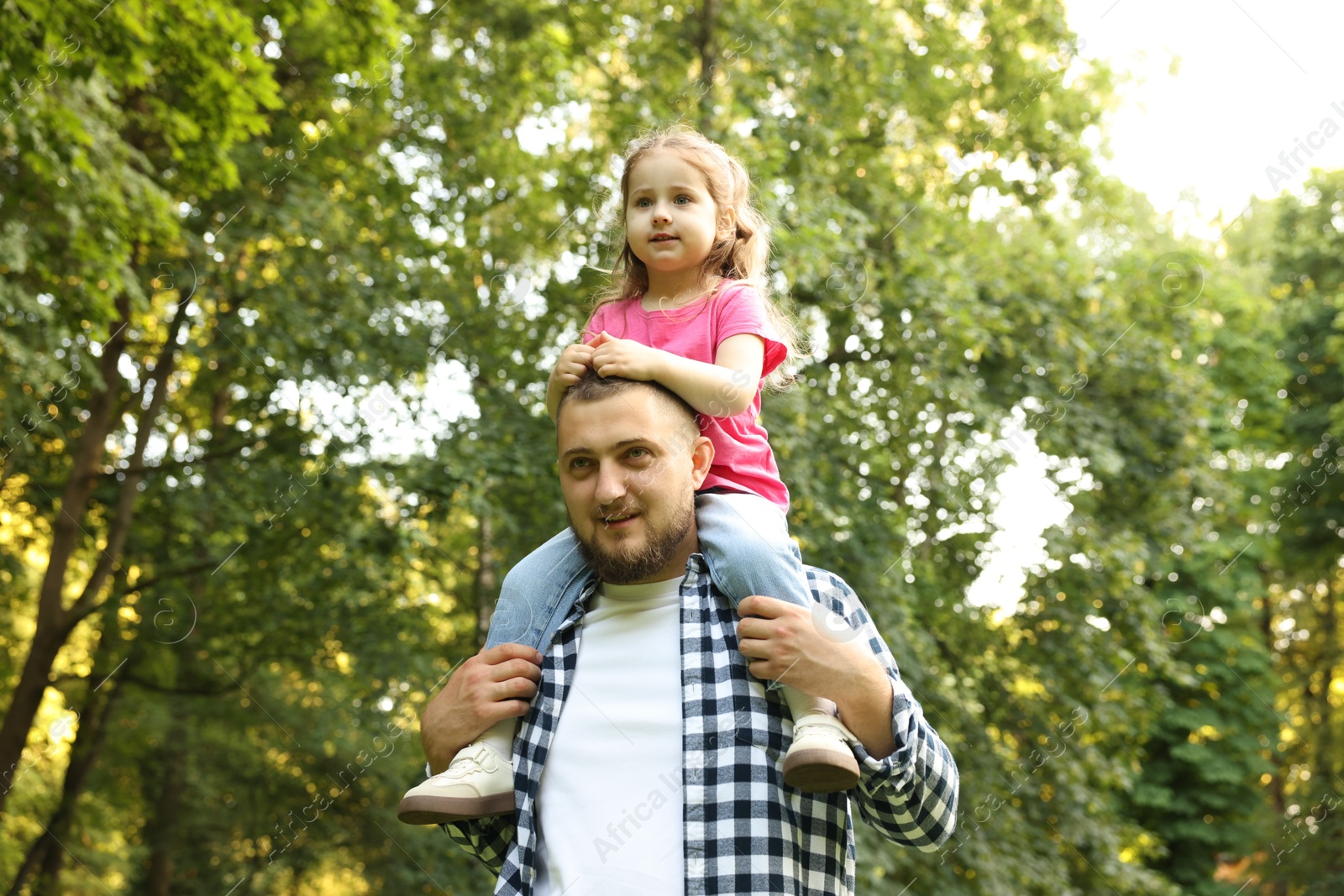 Happy Father's Day. Dad and his little daughter spending time together in park, low angle view Photo of Happy Father's Day. Dad and his little daughter spending time together in park, low angle view