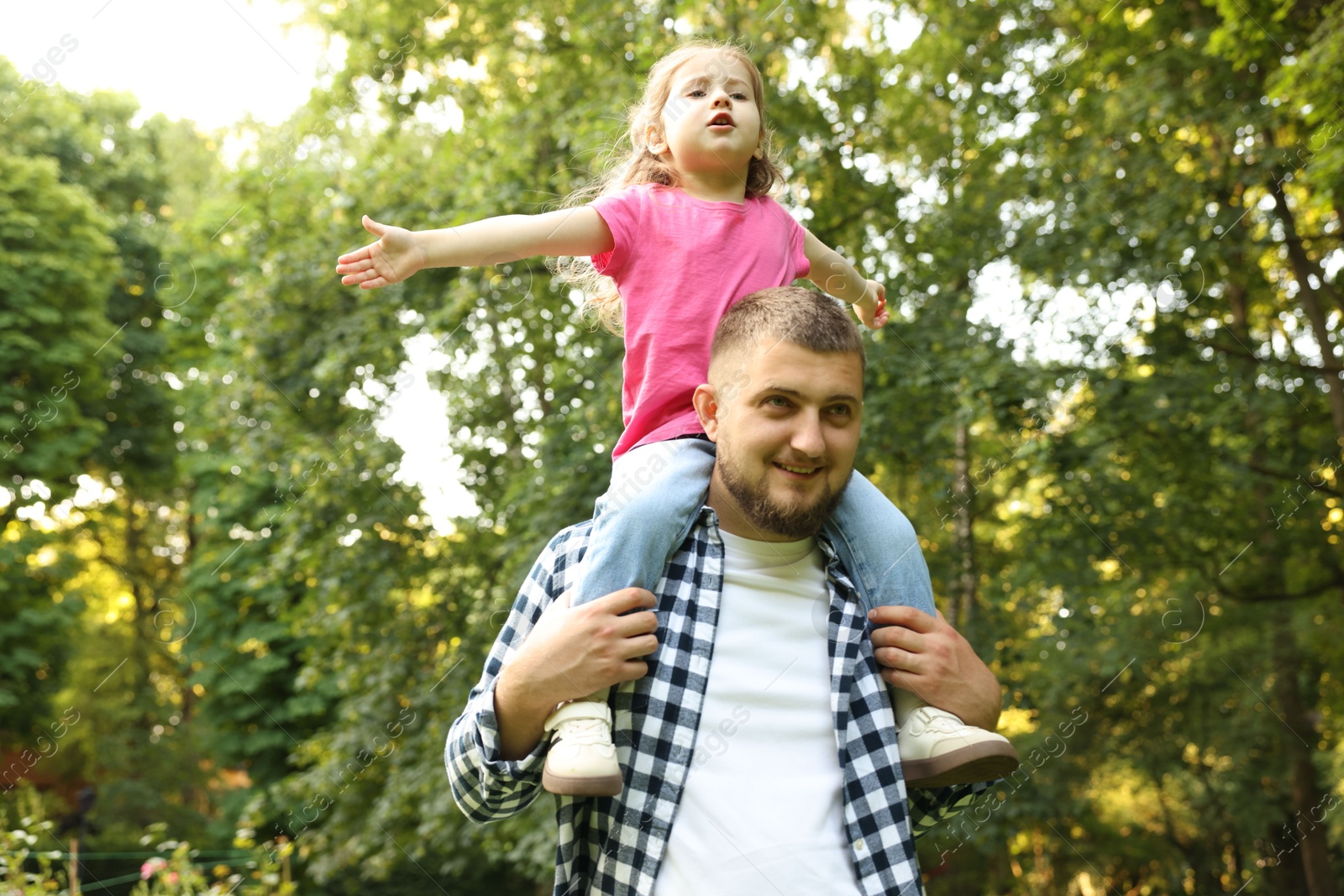 Happy Father's Day. Dad and his little daughter spending time together in park, low angle view Photo of Happy Father's Day. Dad and his little daughter spending time together in park, low angle view