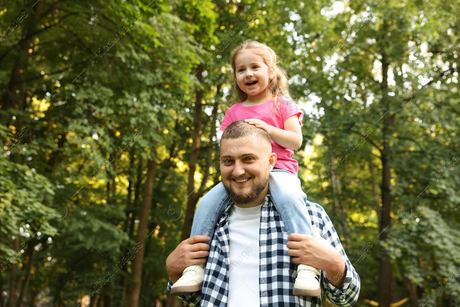 Happy Father's Day. Dad and his little daughter spending time together in park, low angle view. Space for text Photo of Happy Father's Day. Dad and his little daughter spending time together in park, low angle view. Space for text