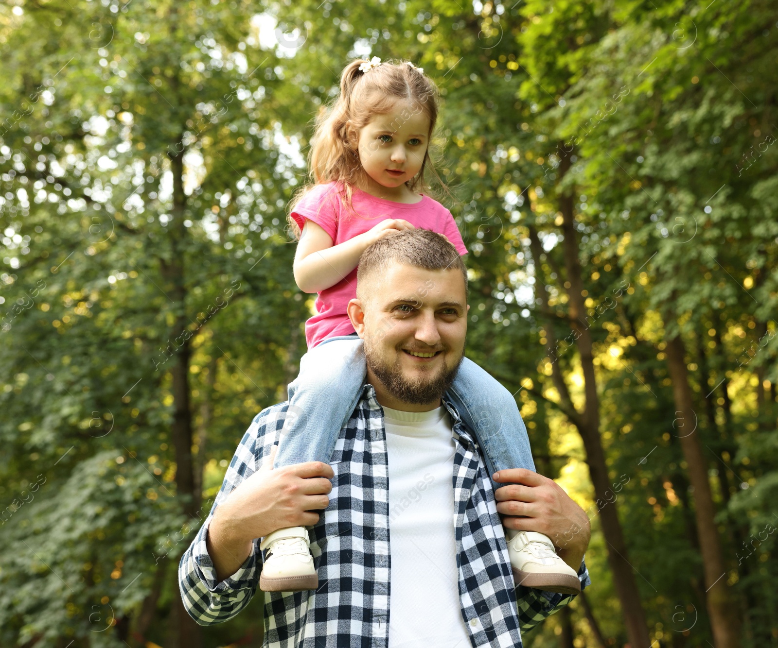 Happy Father's Day. Dad and his little daughter spending time together in park, low angle view Photo of Happy Father's Day. Dad and his little daughter spending time together in park, low angle view