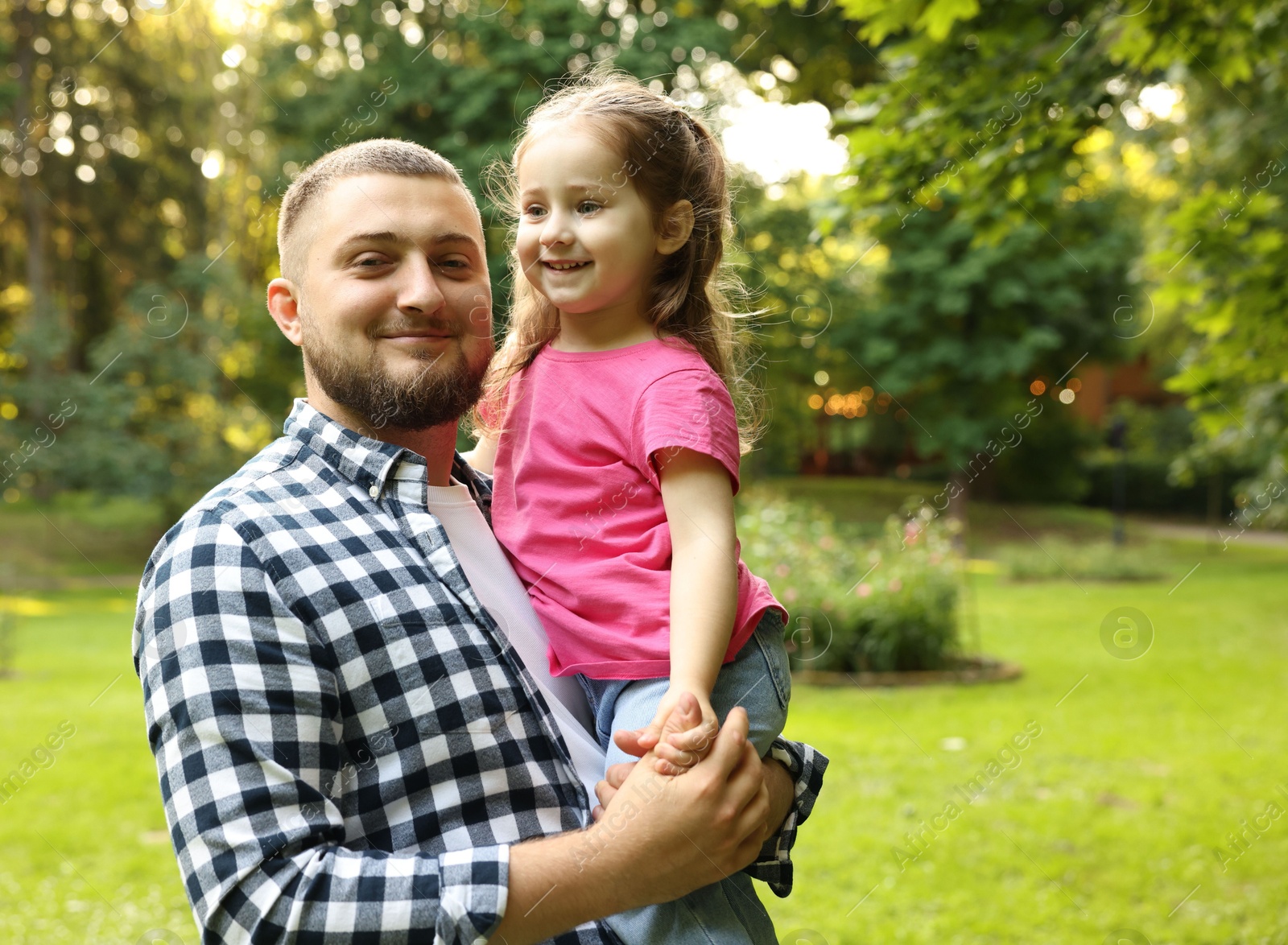 Happy Father's Day. Dad and his little daughter spending time together in park, space for text Photo of Happy Father's Day. Dad and his little daughter spending time together in park, space for text