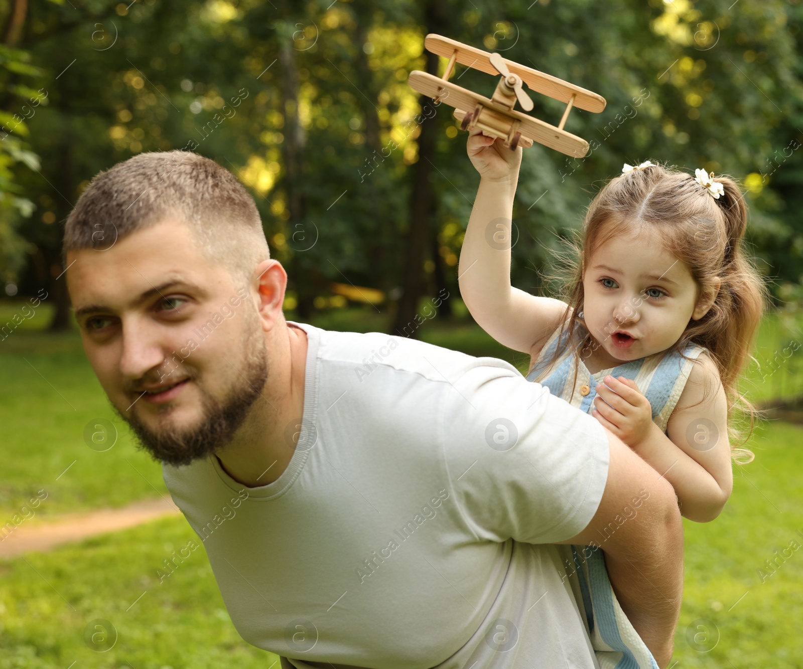 Happy Father's Day. Dad and his little daughter spending time together in park Photo of Happy Father's Day. Dad and his little daughter spending time together in park