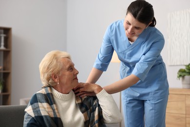 Photo of Nurse assisting senior woman indoors. Home health care service