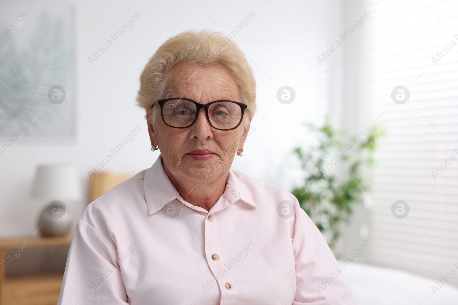Photo of Portrait of senior woman in glasses at home