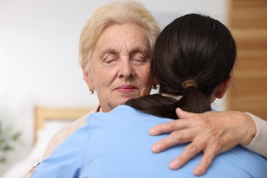 Photo of Nurse assisting senior woman indoors. Home health care service
