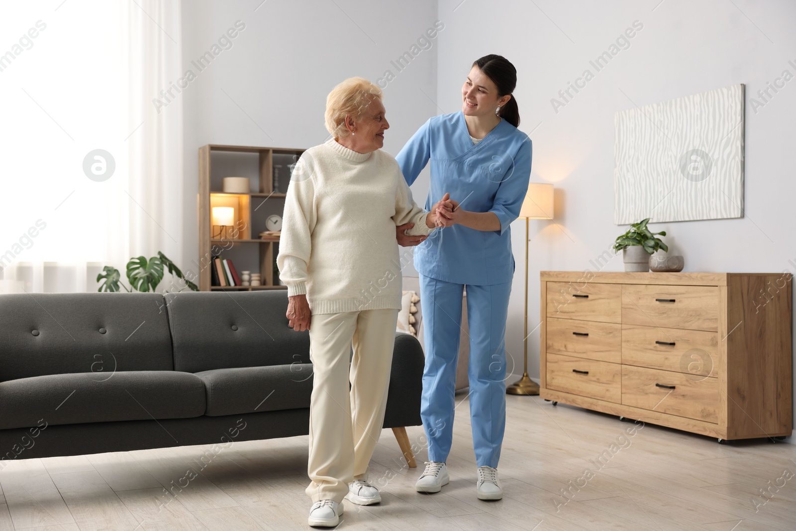Nurse assisting senior woman indoors. Home health care service Photo of Nurse assisting senior woman indoors. Home health care service