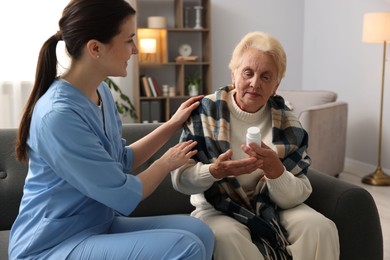 Photo of Nurse assisting senior woman indoors. Home health care service