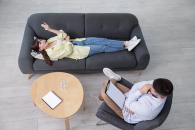 Photo of Professional psychologist working with patient in office, above view