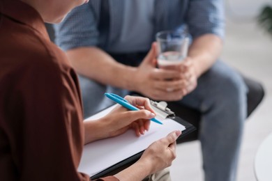 Photo of Professional psychologist working with patient in office, closeup