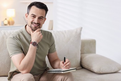 Photo of Professional psychologist with notebook on sofa in office. Space for text
