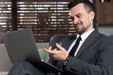 Photo of Professional psychologist having online consultation with his client via laptop indoors