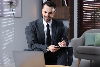 Photo of Professional psychologist having online consultation with his client via laptop indoors