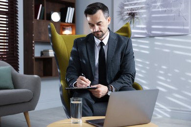 Photo of Professional psychologist having online consultation with his client via laptop indoors