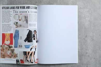 Photo of Open magazine on grey table, top view. Mockup for design