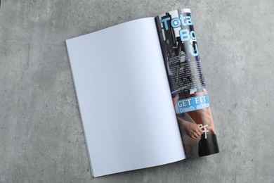 Photo of Open magazine on grey table, top view. Mockup for design