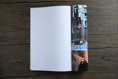 Photo of Open magazine on wooden table, top view. Mockup for design