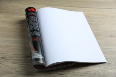 Photo of Open magazine on wooden table, closeup. Mockup for design