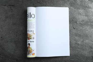 Photo of Open magazine on grey table, top view. Mockup for design