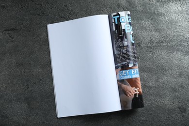 Photo of Open magazine on grey table, top view. Mockup for design