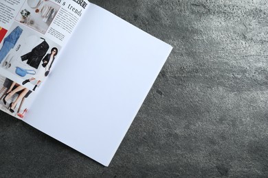 Photo of Open magazine on grey table, top view. Mockup for design