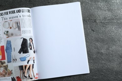 Photo of Open magazine on grey table, top view. Mockup for design