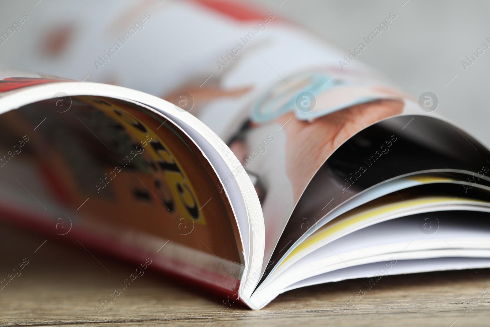 One open magazine on wooden table, closeup Photo of One open magazine on wooden table, closeup