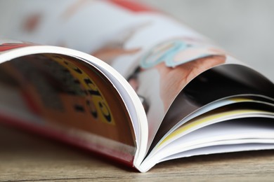 Photo of One open magazine on wooden table, closeup