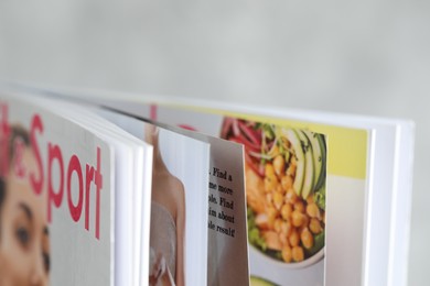Photo of One open magazine on blurred background, closeup