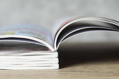 Photo of Stack of different magazines on wooden table, closeup