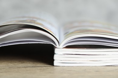 Photo of Stack of different magazines on wooden table, closeup