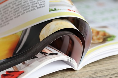 Photo of One open magazine on wooden table, closeup