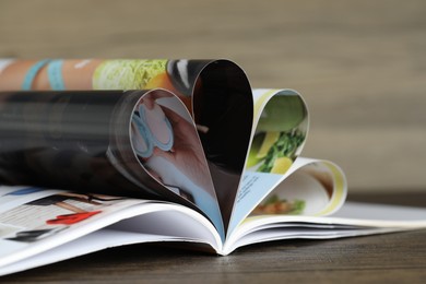 Photo of One open magazine on wooden table, closeup