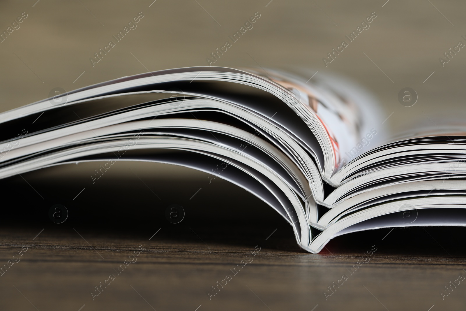 Different open magazines on wooden table, closeup Photo of Different open magazines on wooden table, closeup