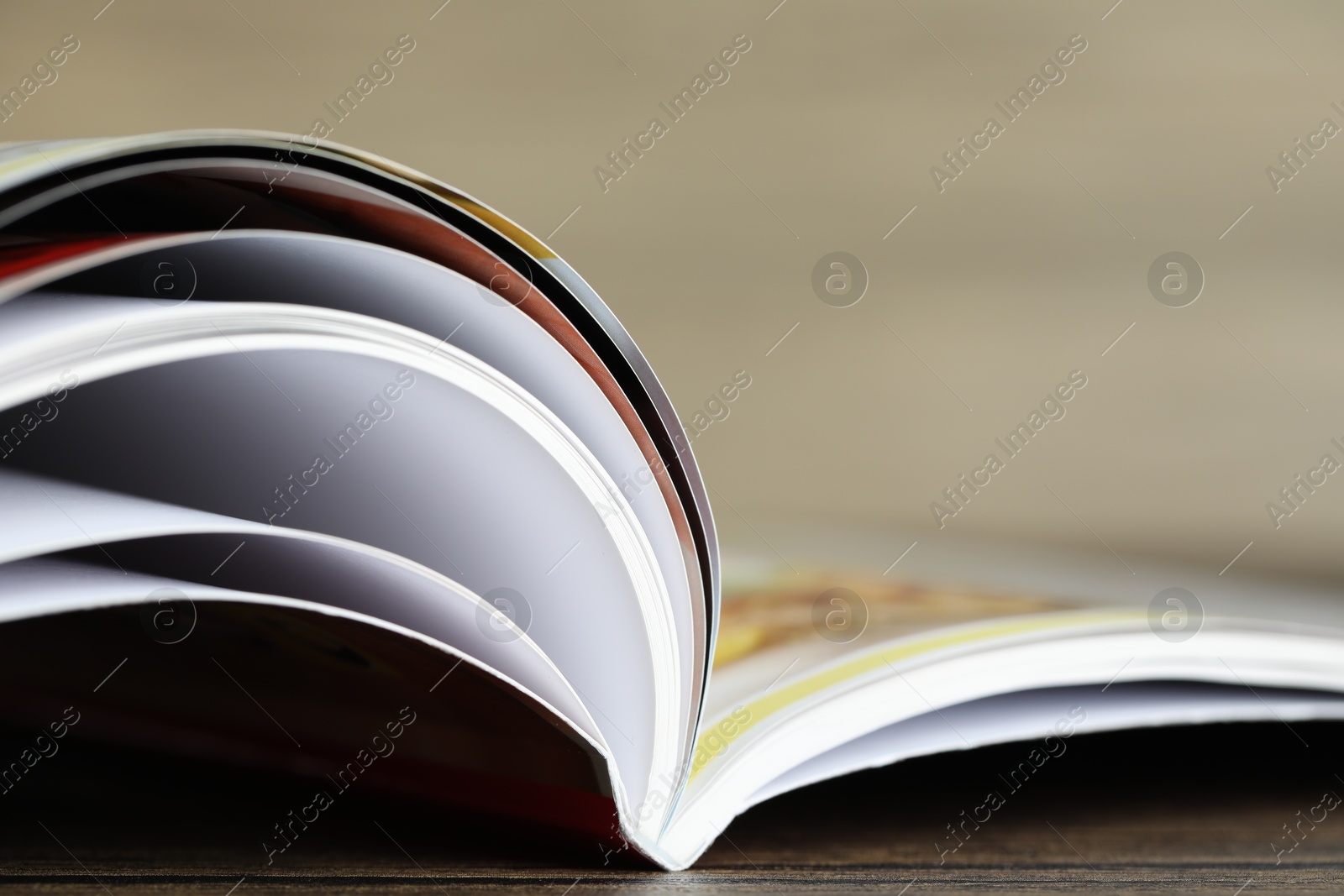 One open magazine on wooden table, closeup Photo of One open magazine on wooden table, closeup