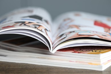 Photo of Stack of different magazines on wooden table, closeup